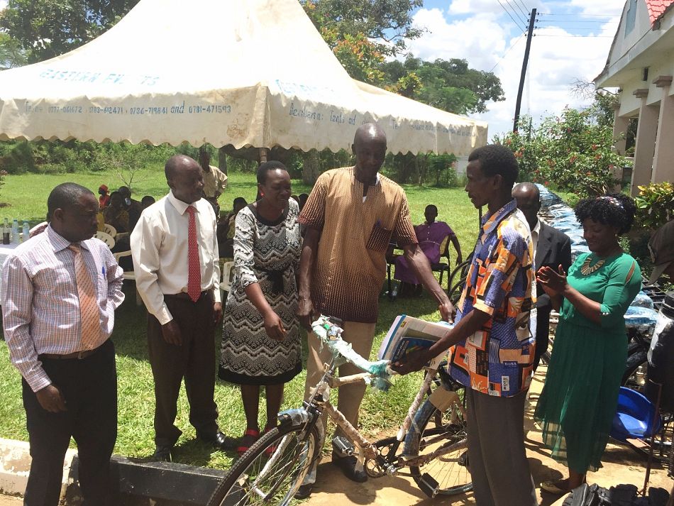 pA member of the village health team receives the first bicycle which is officially presented to him by district leadersp
