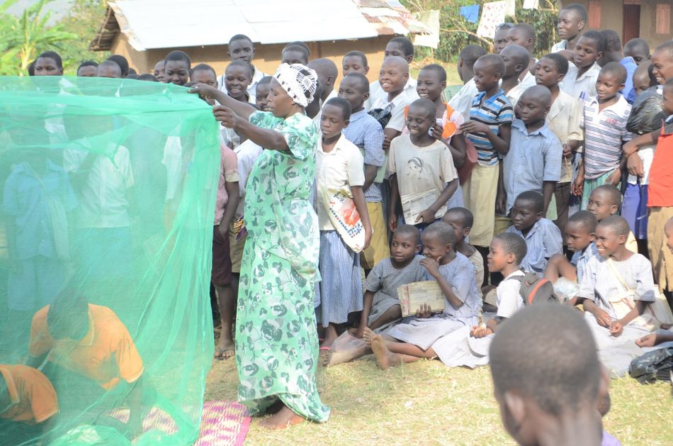 pCommunity members and in particular the young children watch as the performers teach them how to hang a mosquito net before going to sleepp