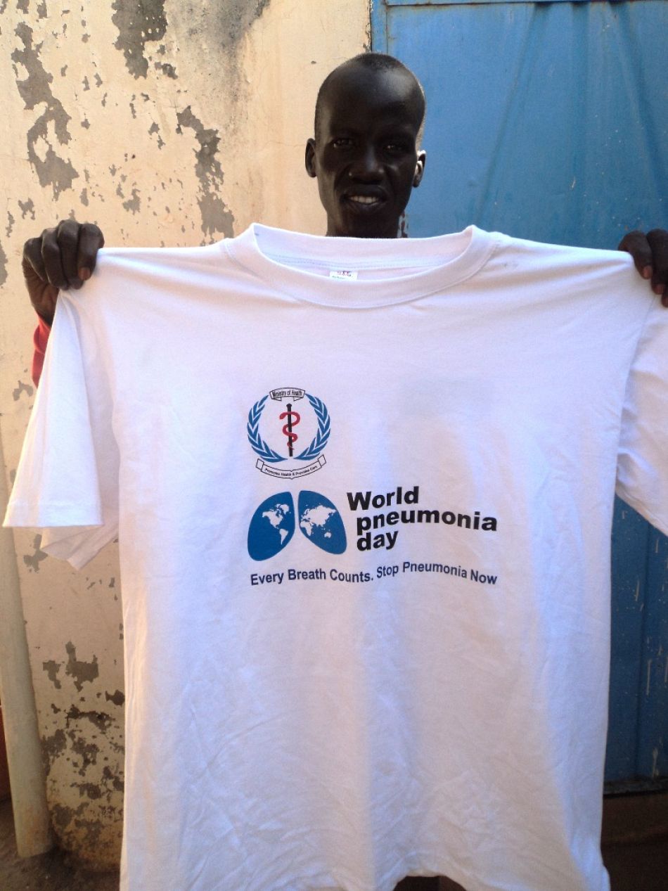 pPneumonia Diagnostics Research Assistant Gabriel Garang holding up thenbspa tshirt for World Pneumonia Dayp
