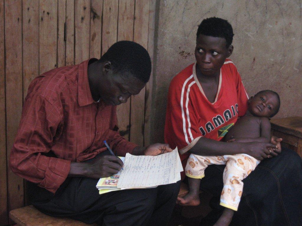 Community health worker recording treatment for a sick child
