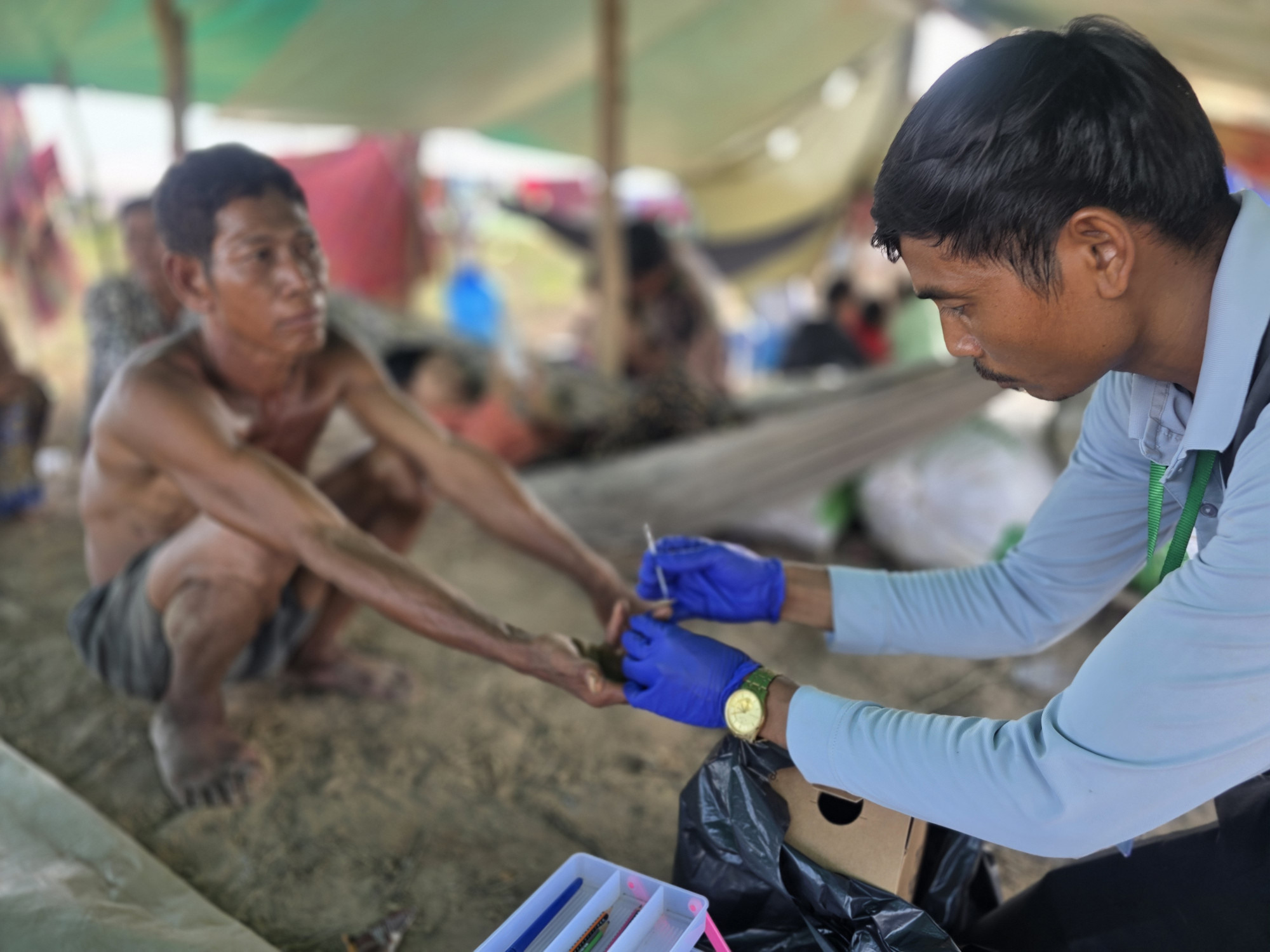 A mobile malaria worker performing a malaria test on an internally displaced person at a camp in Prear Vihear province, Cambodia