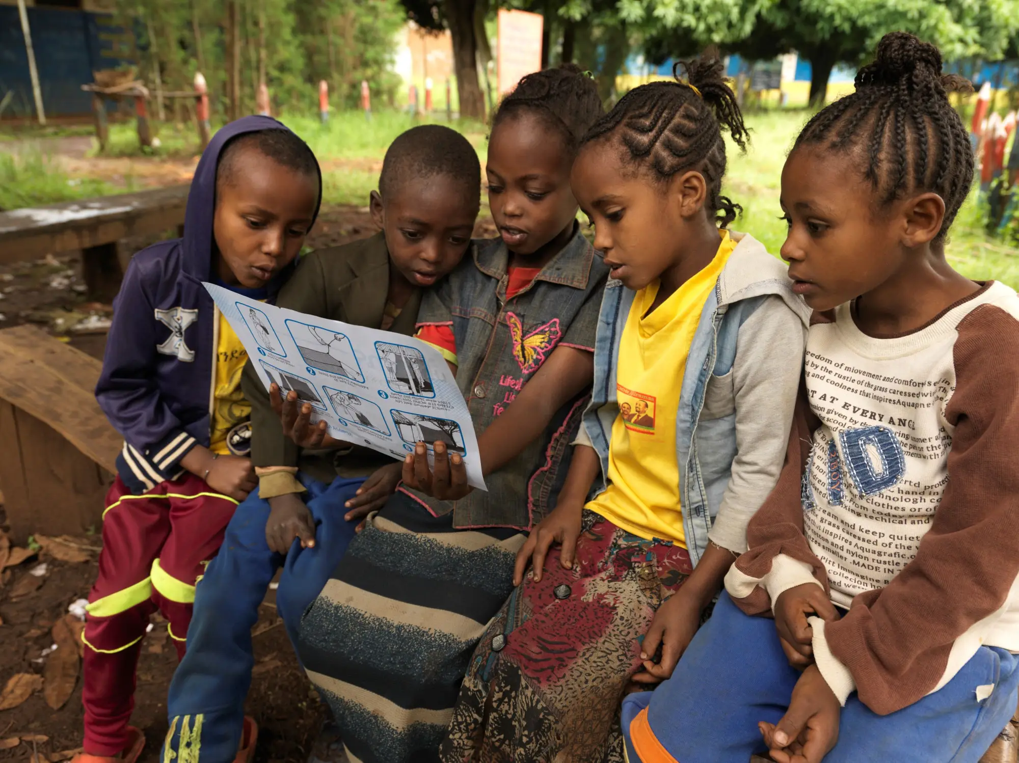Children at the Himbecho Primary School in Boloso Sore studying illustrations on malaria prevention.