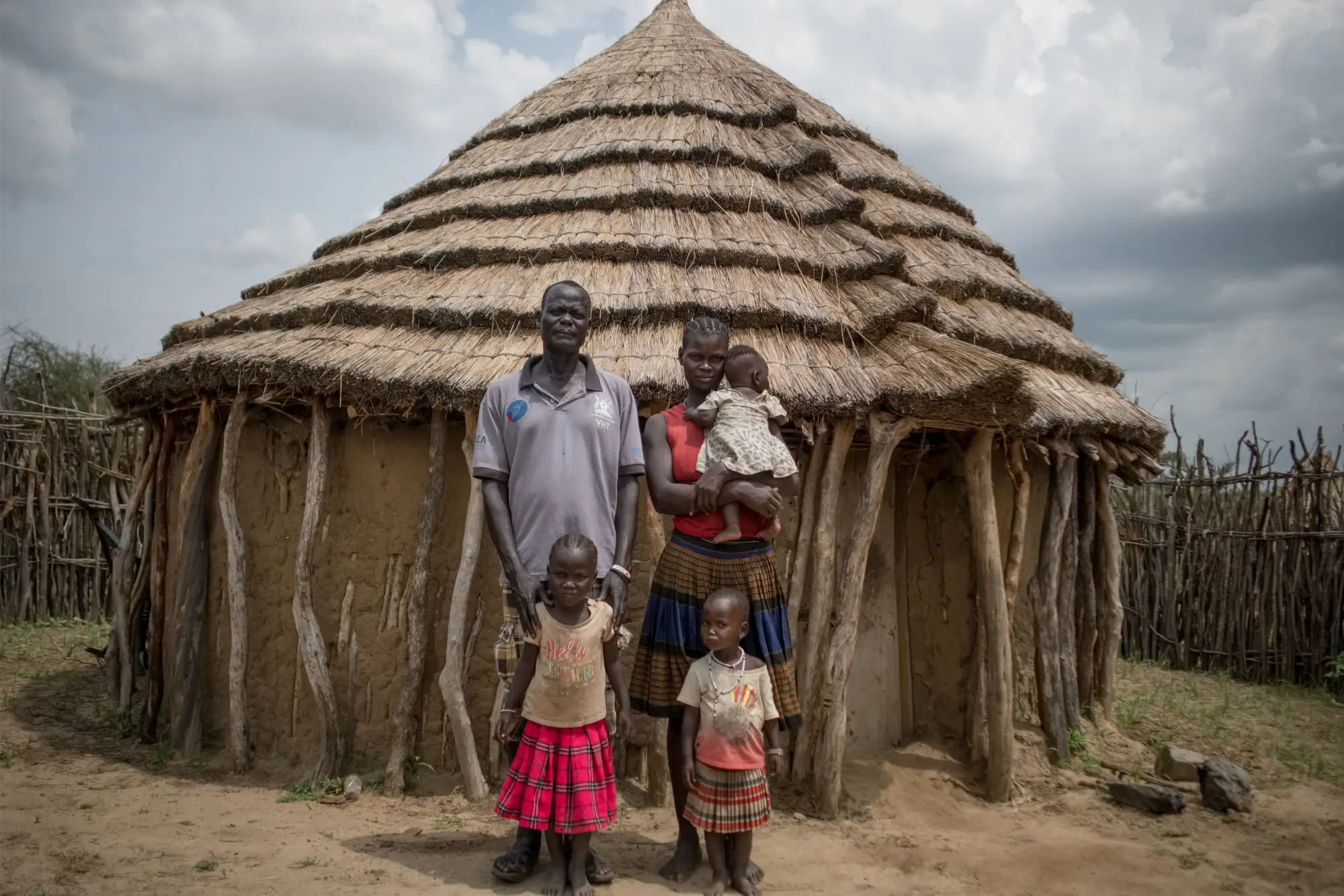 A family stand outside their home in Karamoja, Uganda in 2022