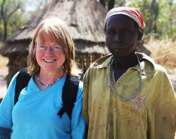 A woman, Sylvia Meek, standing next to a male community member