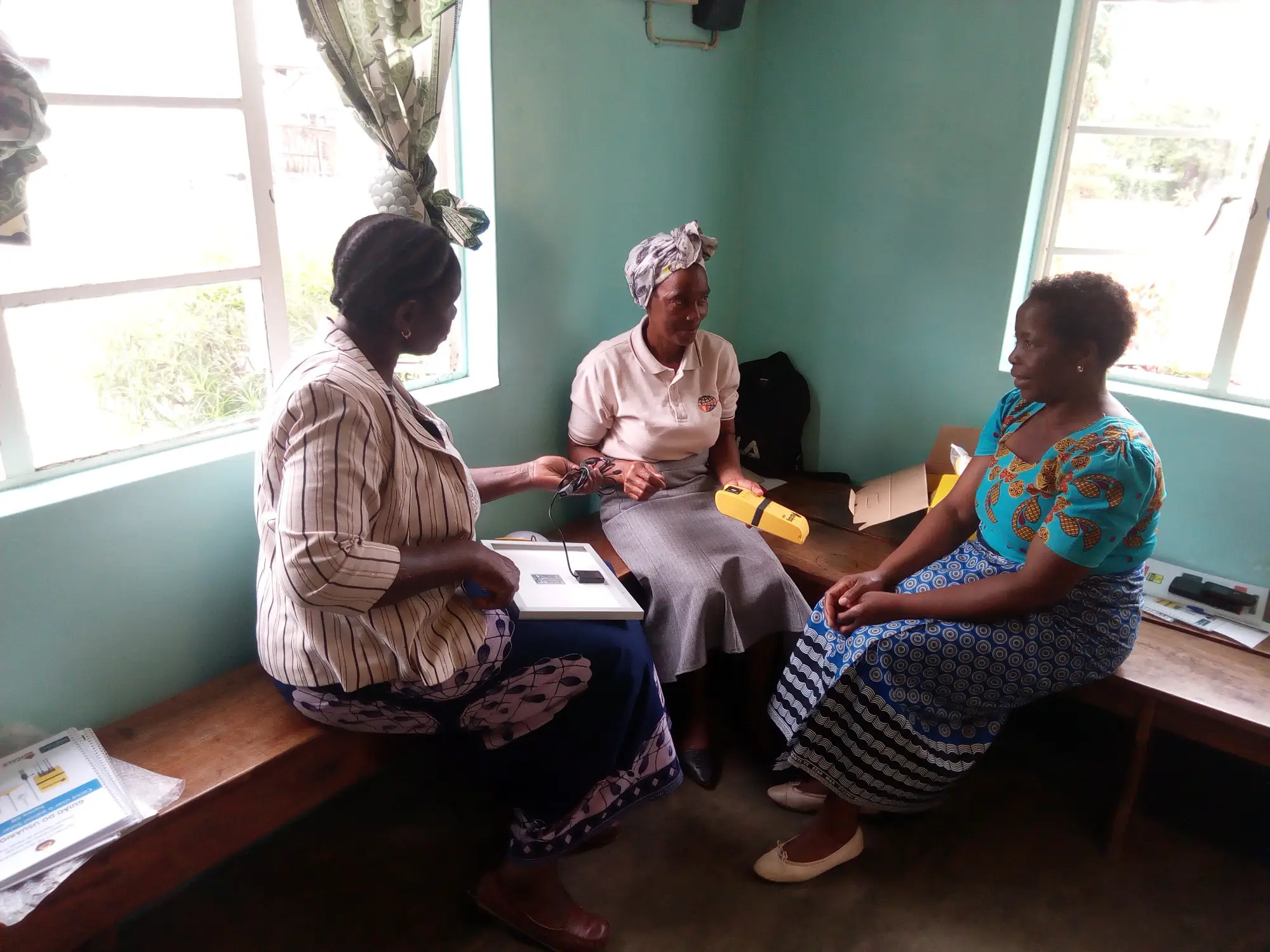 Three people, the members of the Mozambique upSCALE working group for solar panel testing, have a discussion