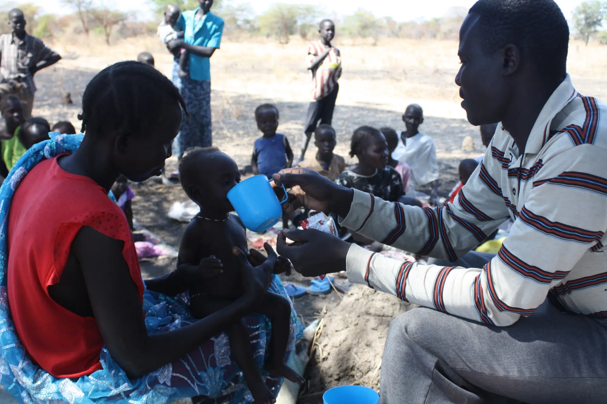 26 Aknot Aleu Wol and child Akuol Piol Deng community OTP CNW Simon Deng Garrang gives plumpy nut Hong Village Aweil West S Sudan Dec 2012