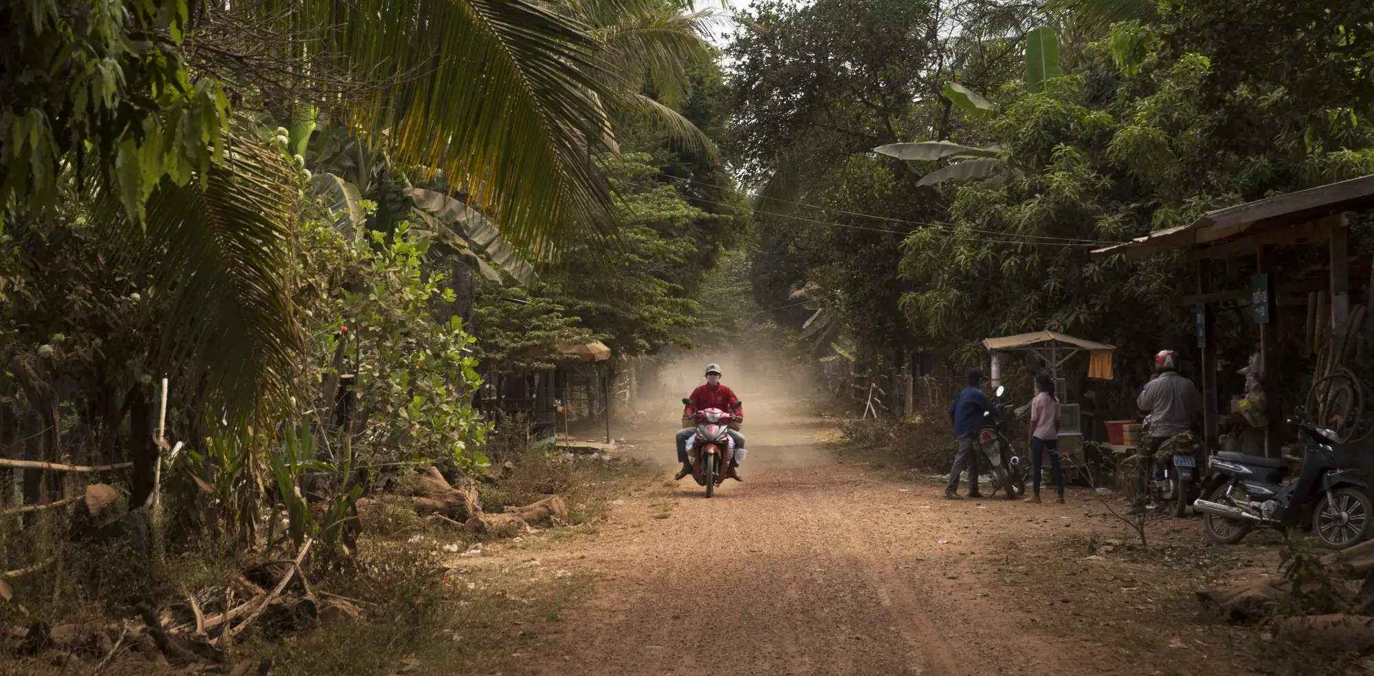 A healthcare worker rides on a motorbike in Cambodia as part of the case detection team