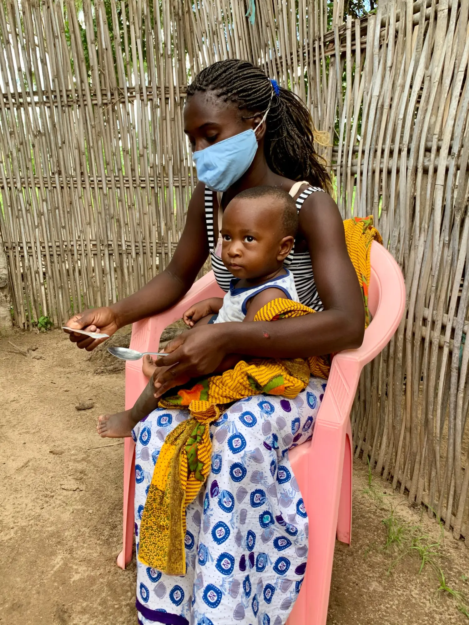 A woman prepares medicine for a child, as part of SMC rollout efforts in Mozambique