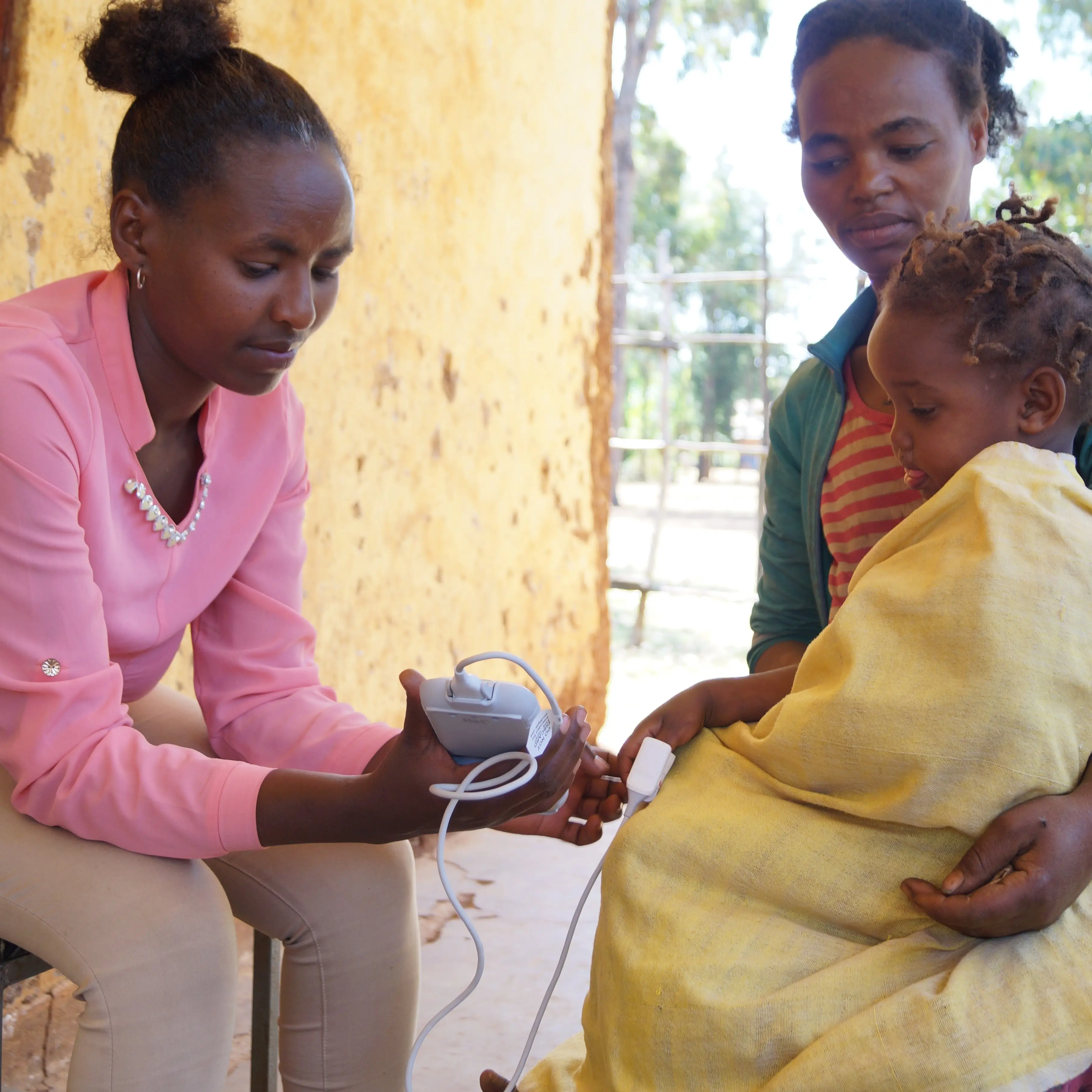 A health worker uses a medical device to test for respiratory infections in a child in Ethiopia, 2017