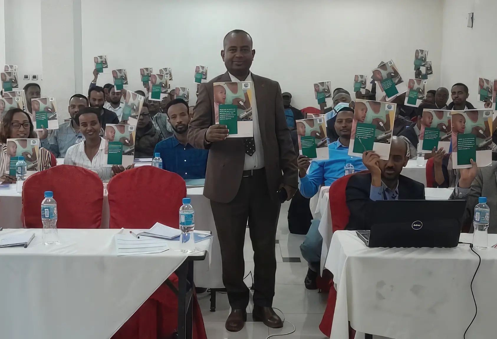 Dr Zelalem Kefene, Project Coordinator at Malaria Consortium Ethiopia, holds a copy of the Action Plan at the dissemination event in June 2023