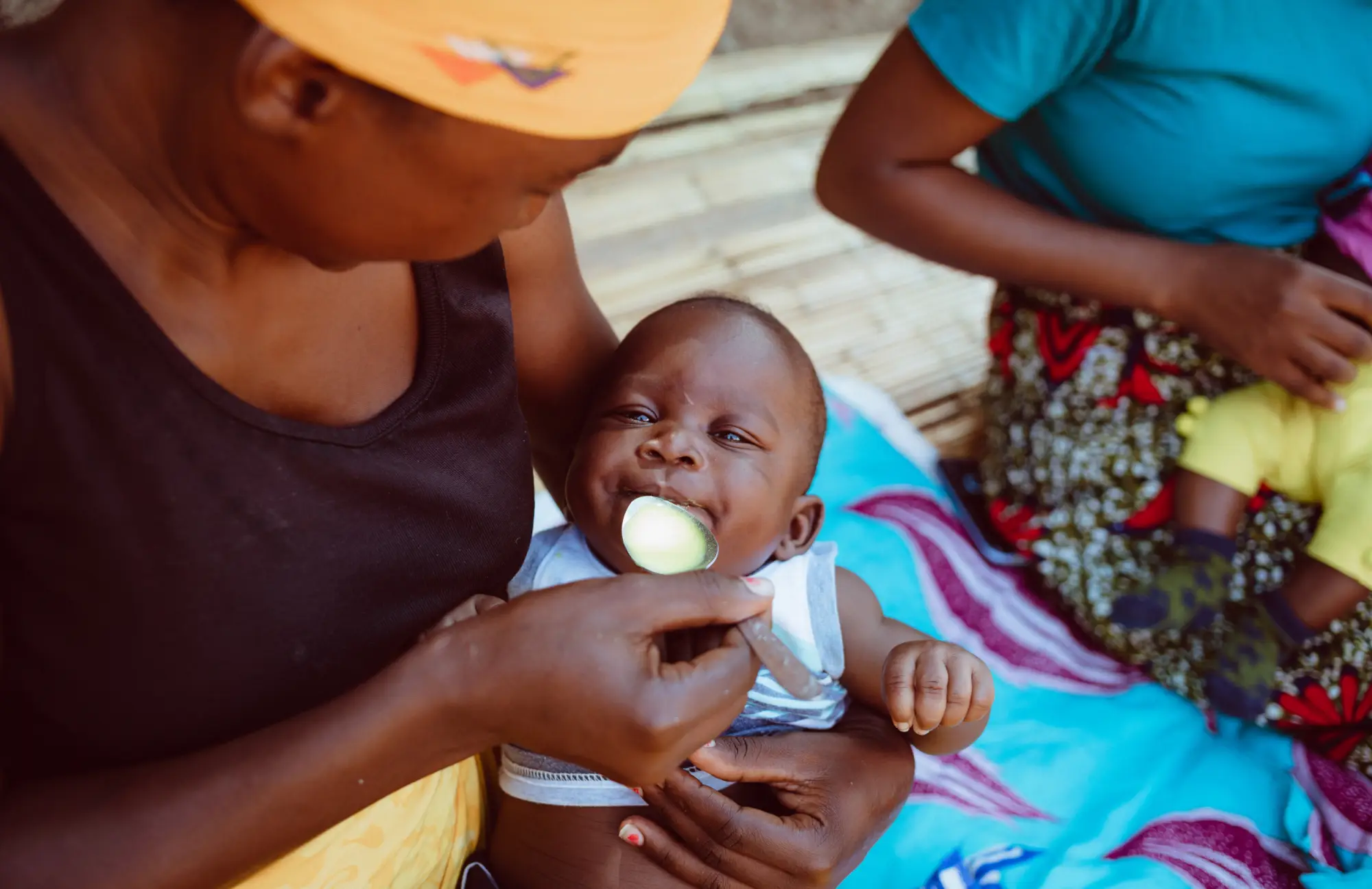 A woman feeds medicine to a child in Mozambique