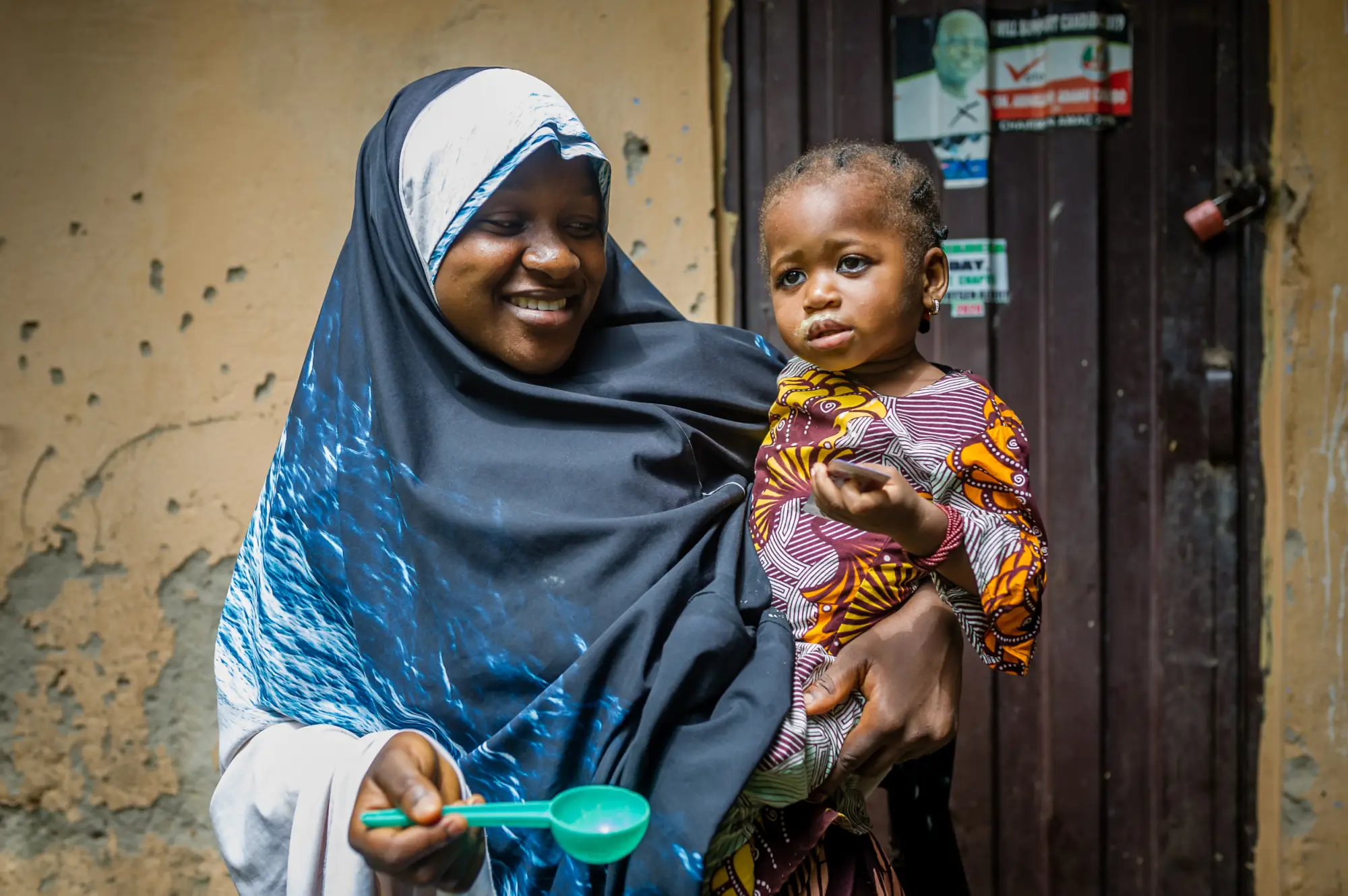 A woman offering SMC medication to a child