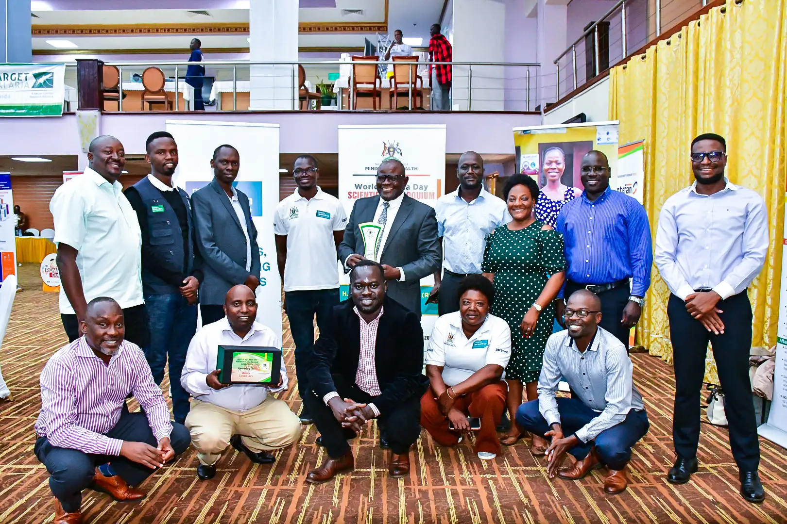 Malaria Consortium Uganda team members with award at World Malaria Day Scientific Colloquium, April 2024