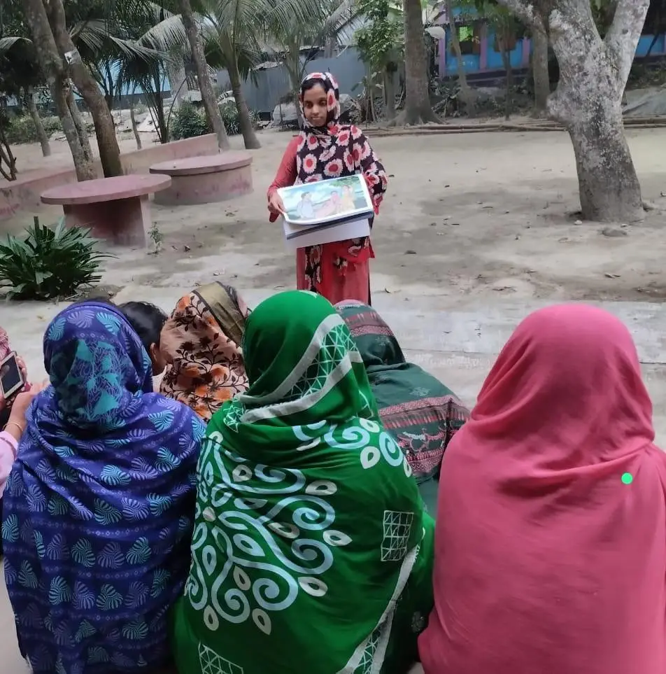 Fatema, a community dialogue facilitator in Bangladesh, talks to women as part of the COSTAR project
