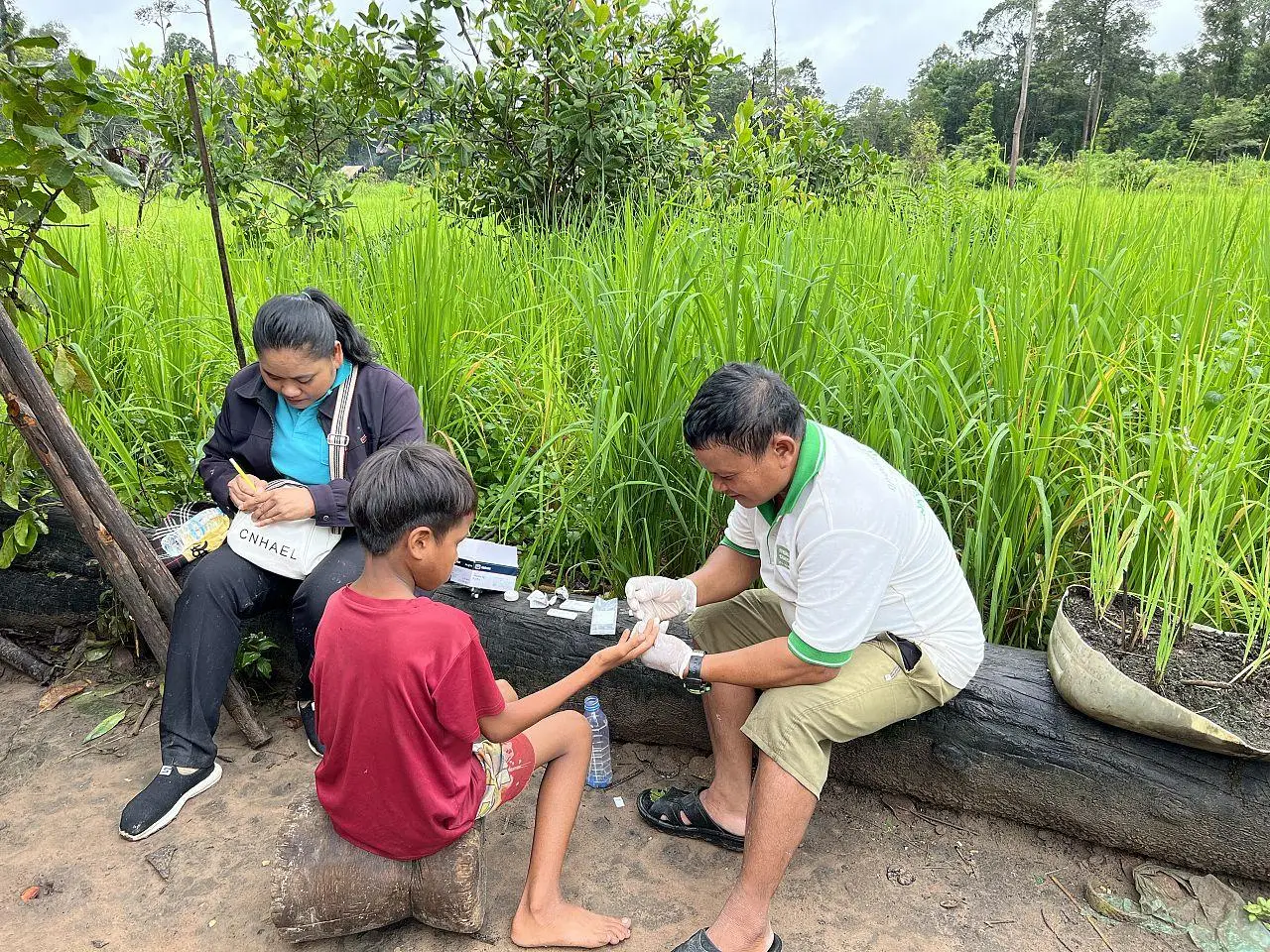 San, a mobile malaria worker, tests a boy for malaria, Cambodia