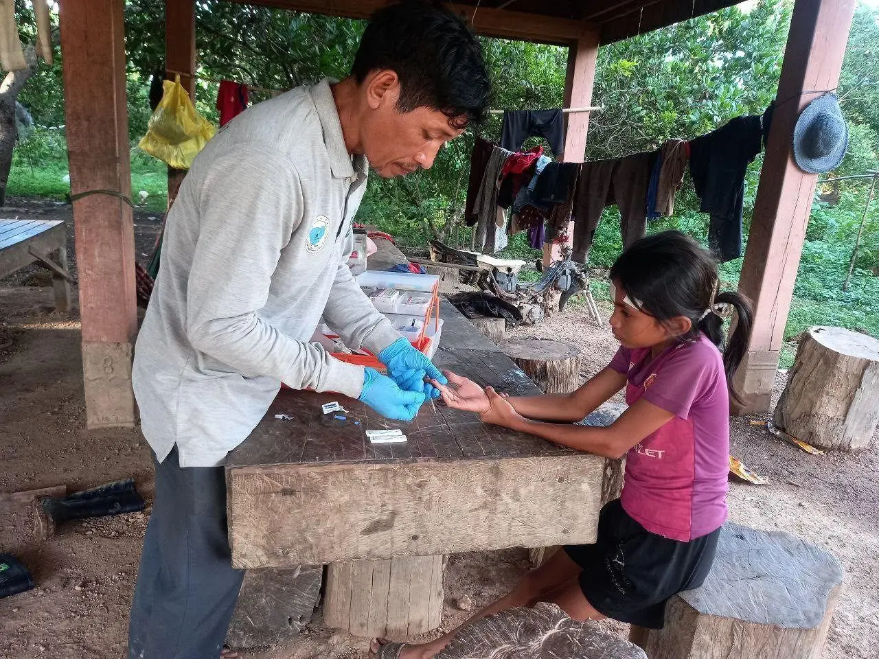 Girl with fever visits the local mobile malaria worker’s house to ask for a malaria test, Mondolkiri province, Cambodia