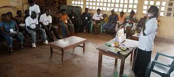 A Breaking Barriers trained community volunteer stands in a room addressing a group of community members