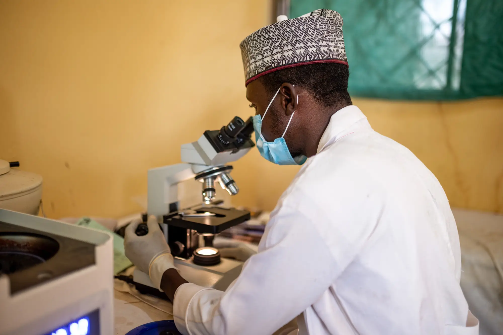 A clinician views a sample under a microscopic in Jigawa, Nigeria