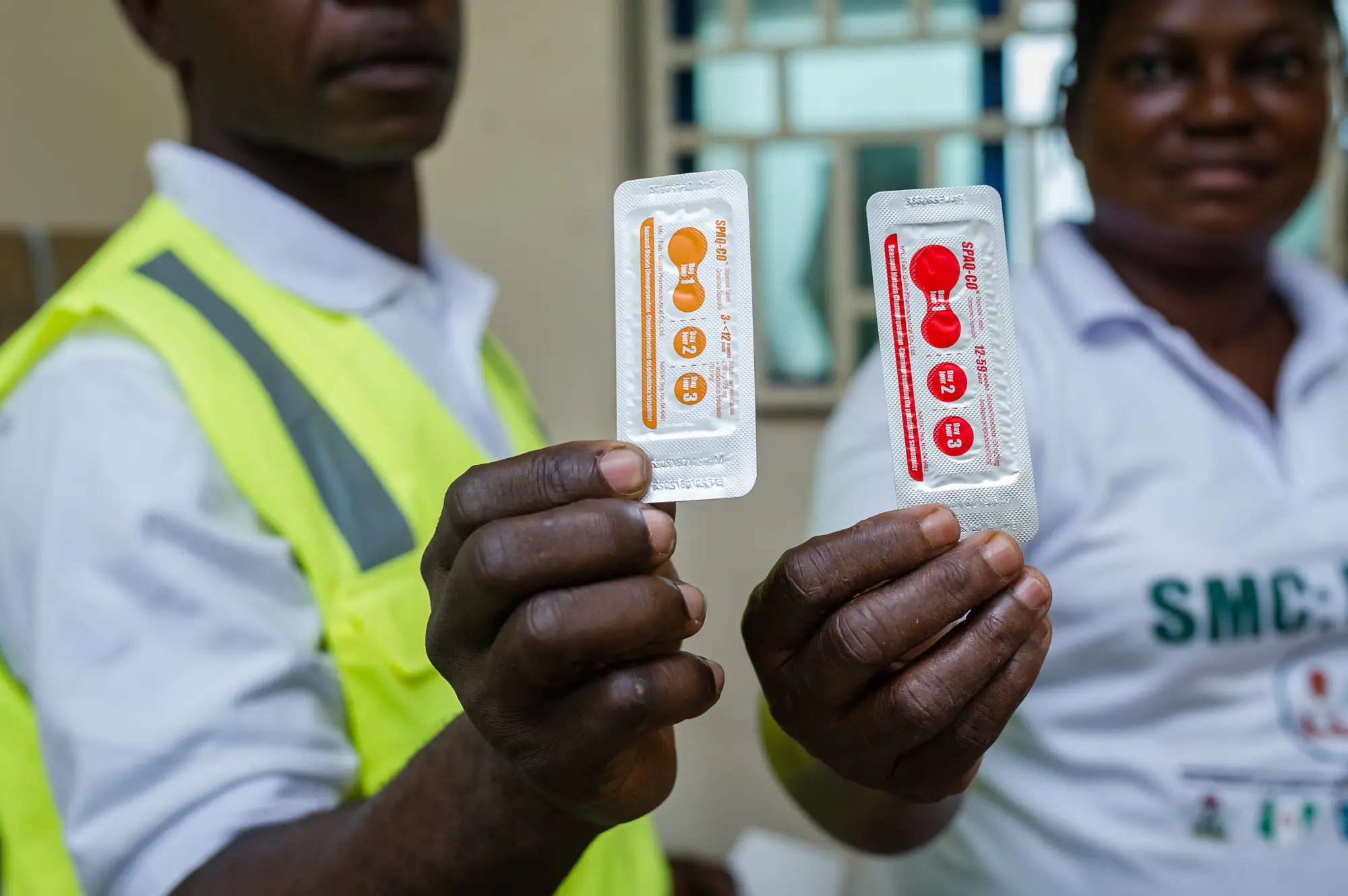 Two healthcare workers show the SMC medication, as part of the SMC efforts in Nigeria