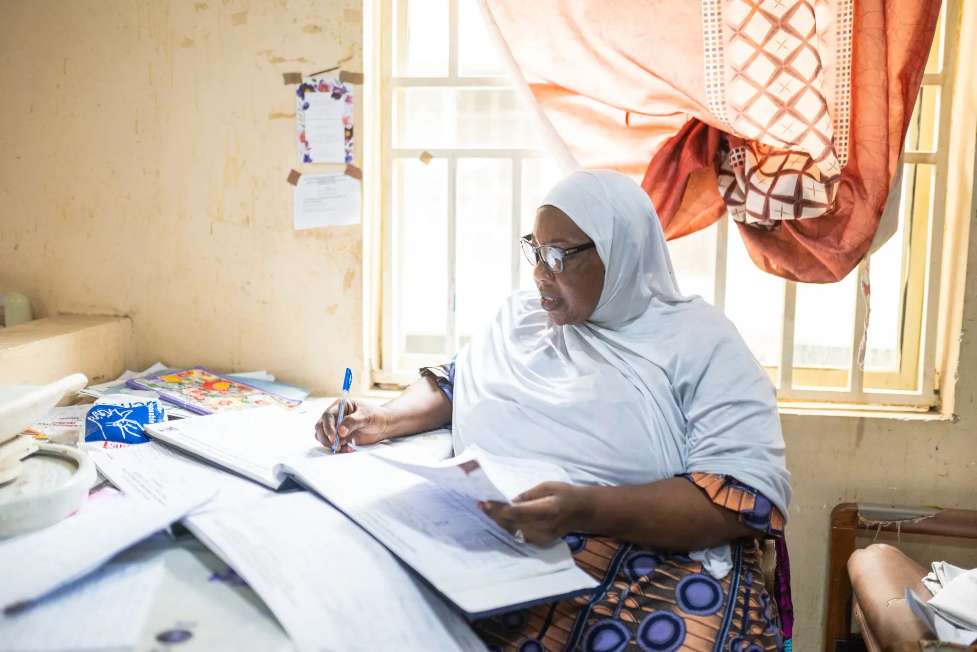 A matron is preparing to administer artusunate to a patient by recording the doses in a register as part of the Severe Malaria Project in Kano state, Nigeria, 2023