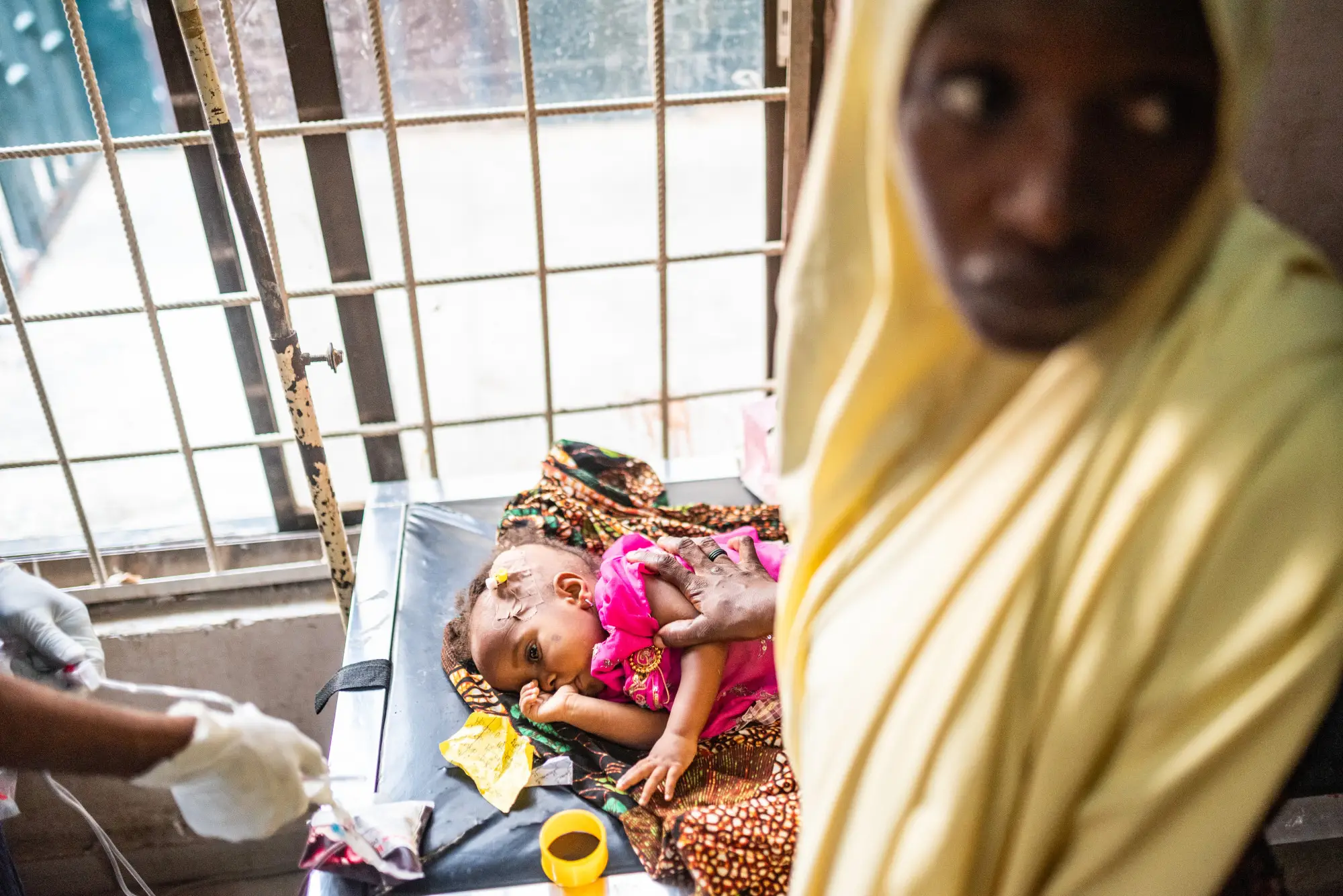 A mother with a child having a blood transfusion to her head