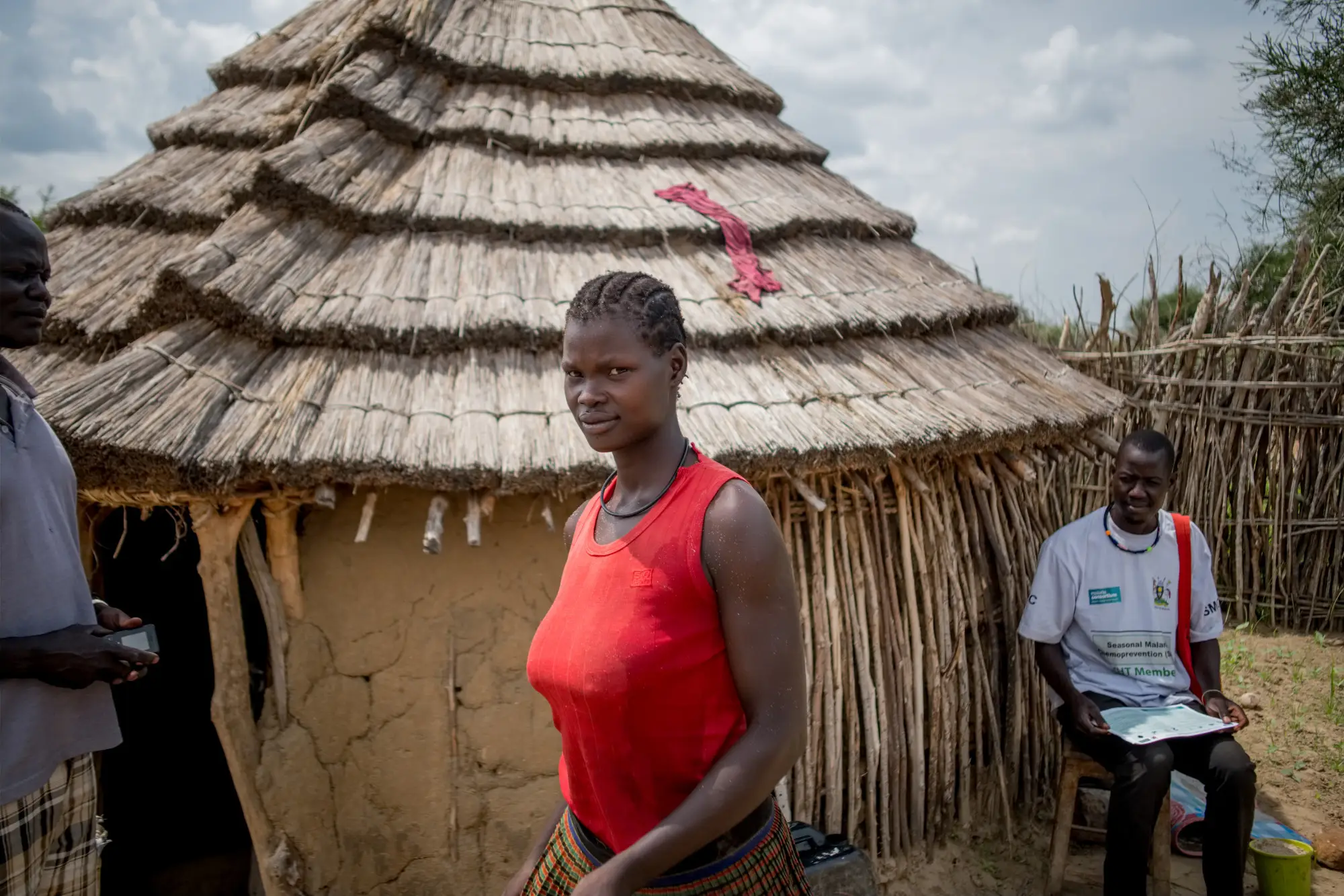 A woman standing in front her hut in Uganda, 2022