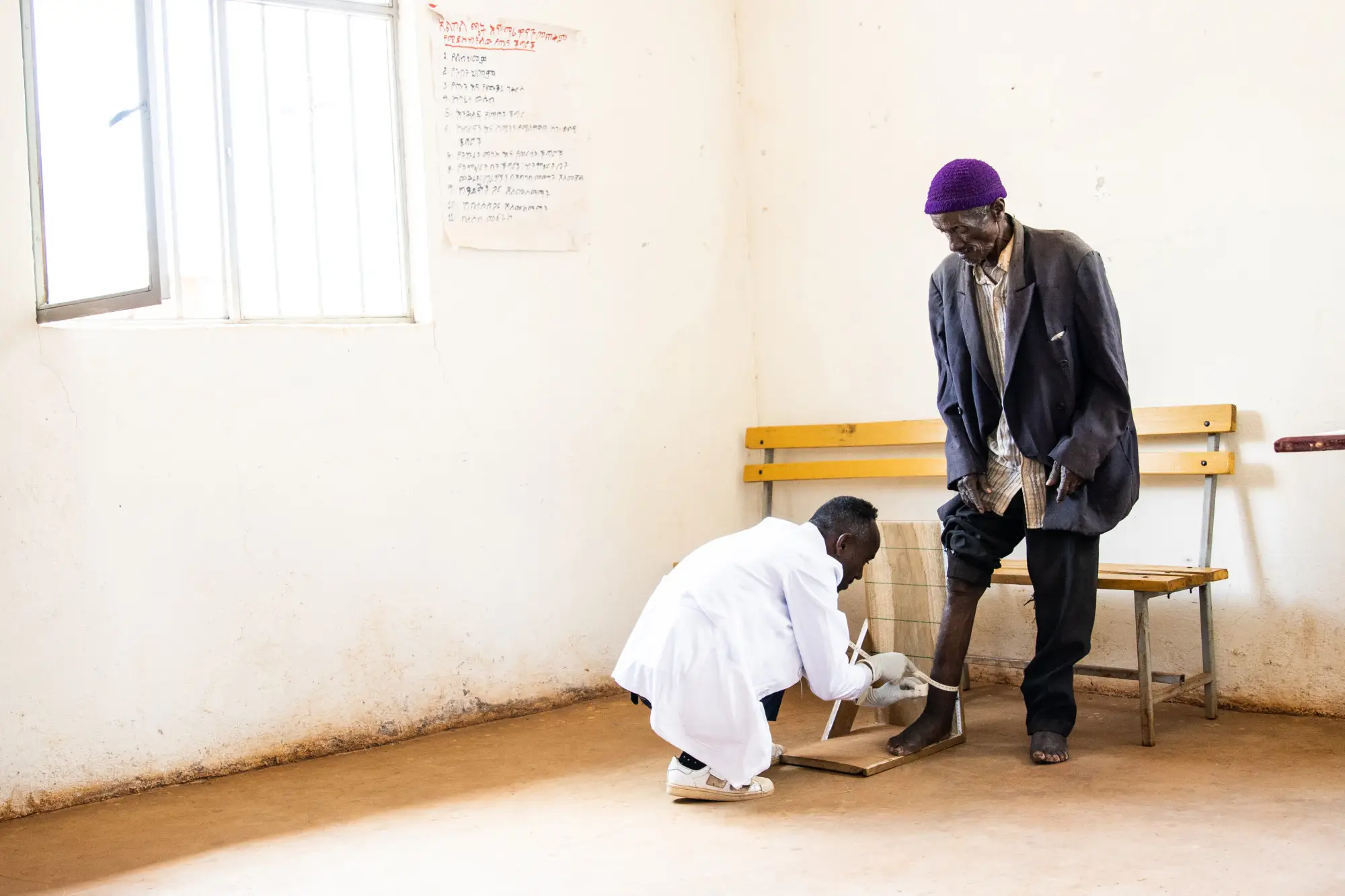 A health worker measures the feet of a man as part of the Happy Feet project in Ethiopia