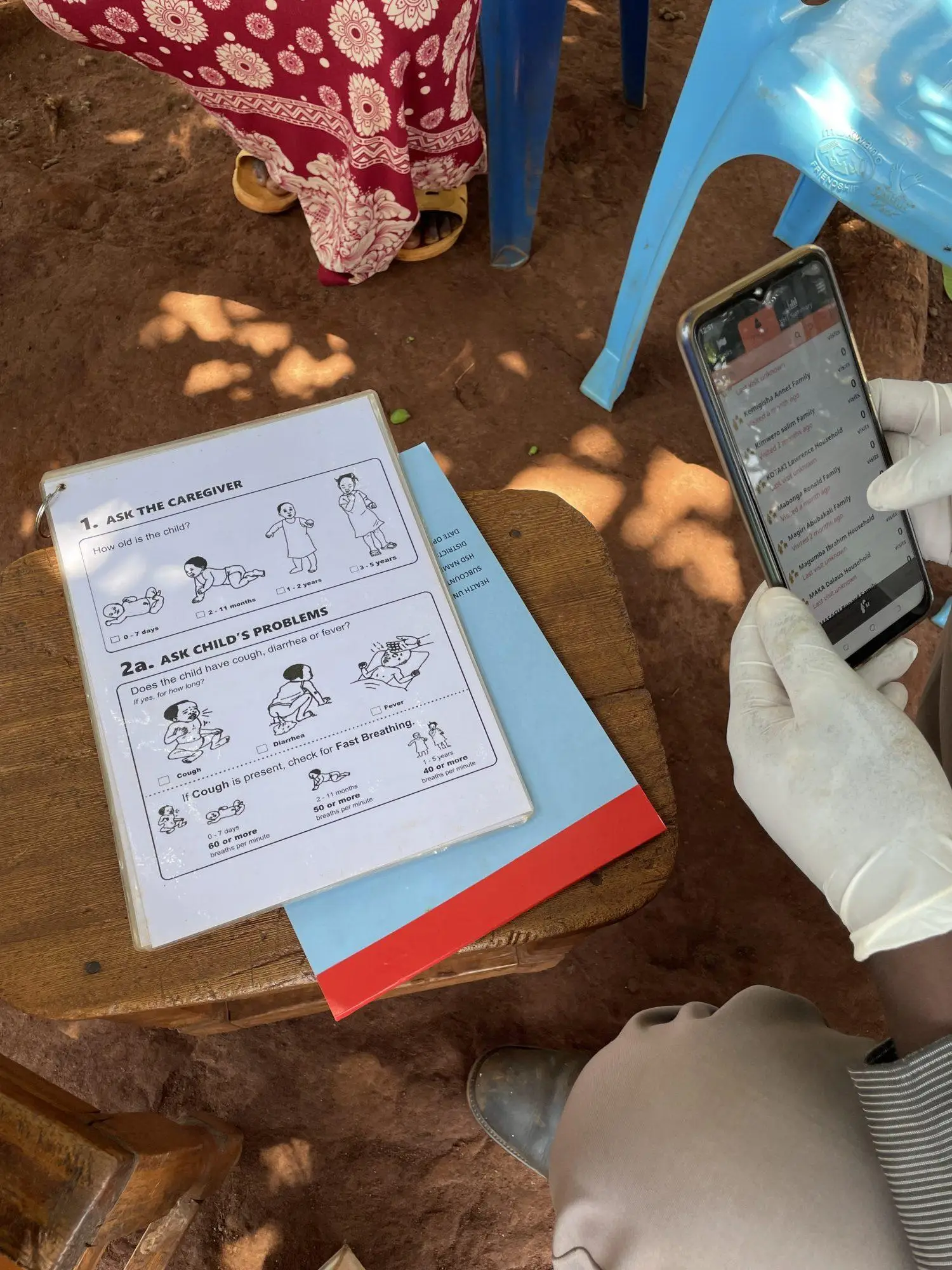 A healthcare worker uses a tablet to log data