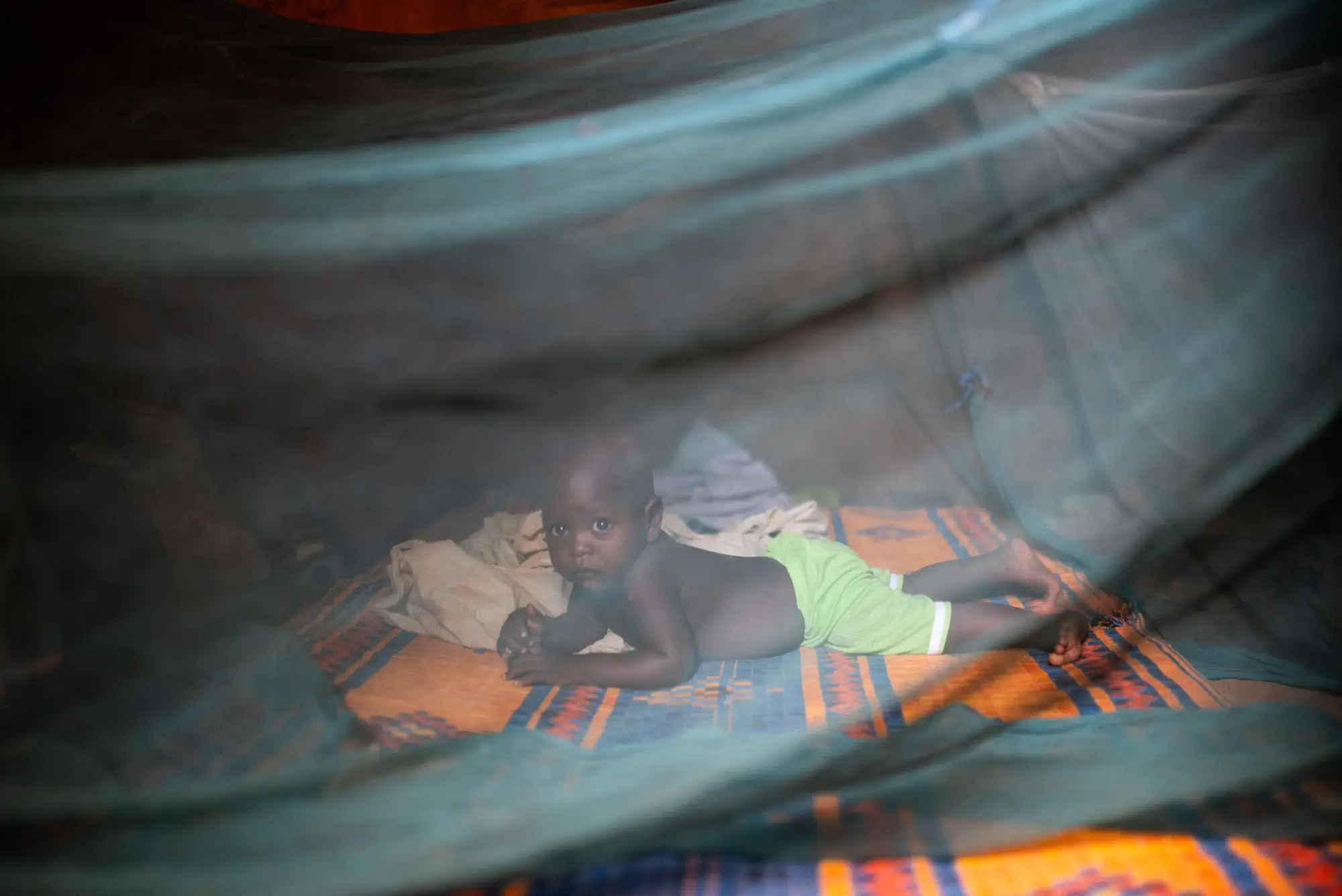 A child sitting under a bed net in Jigawa, Nigeria in 2023