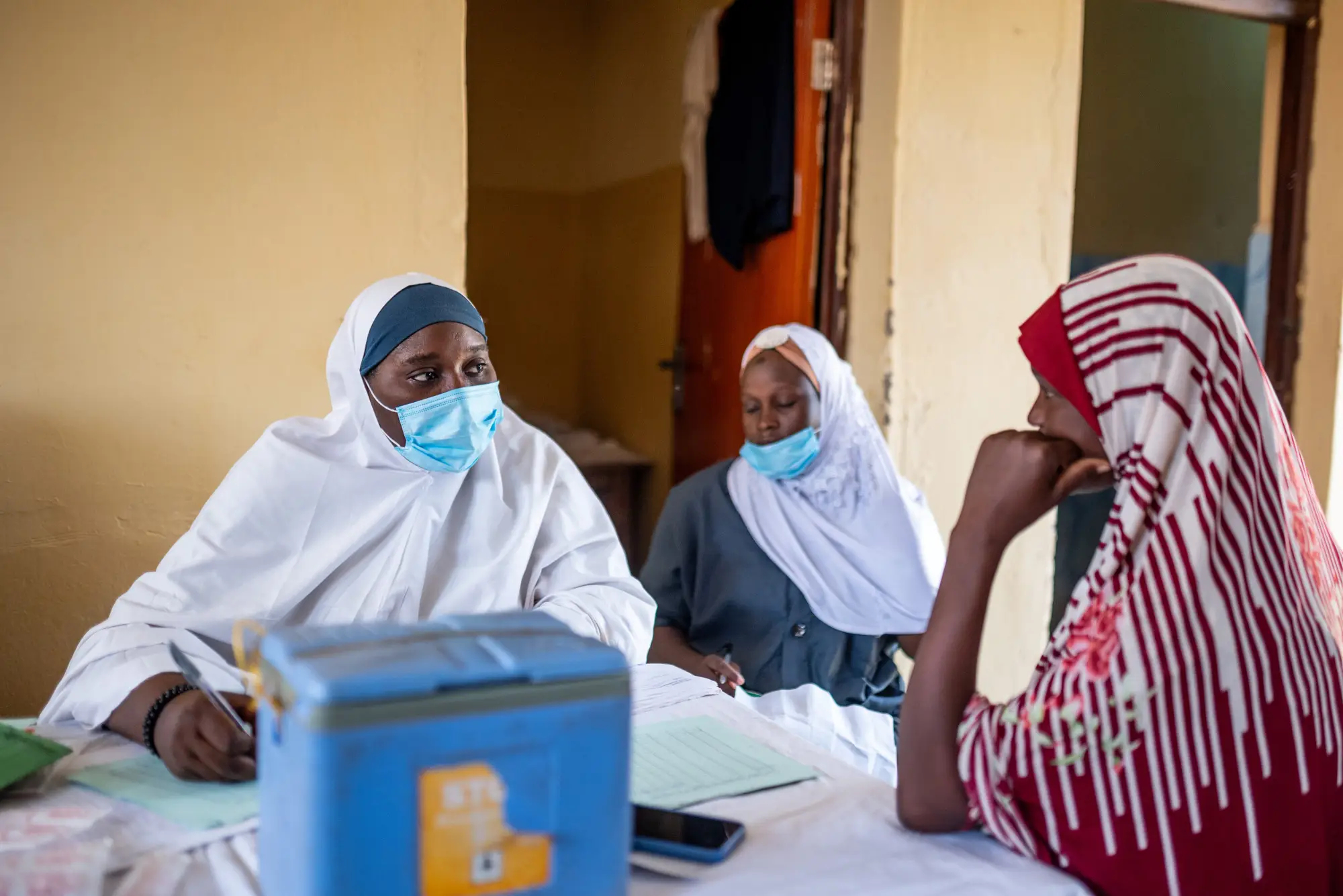 A community worker takes a woman's information in Nigeria