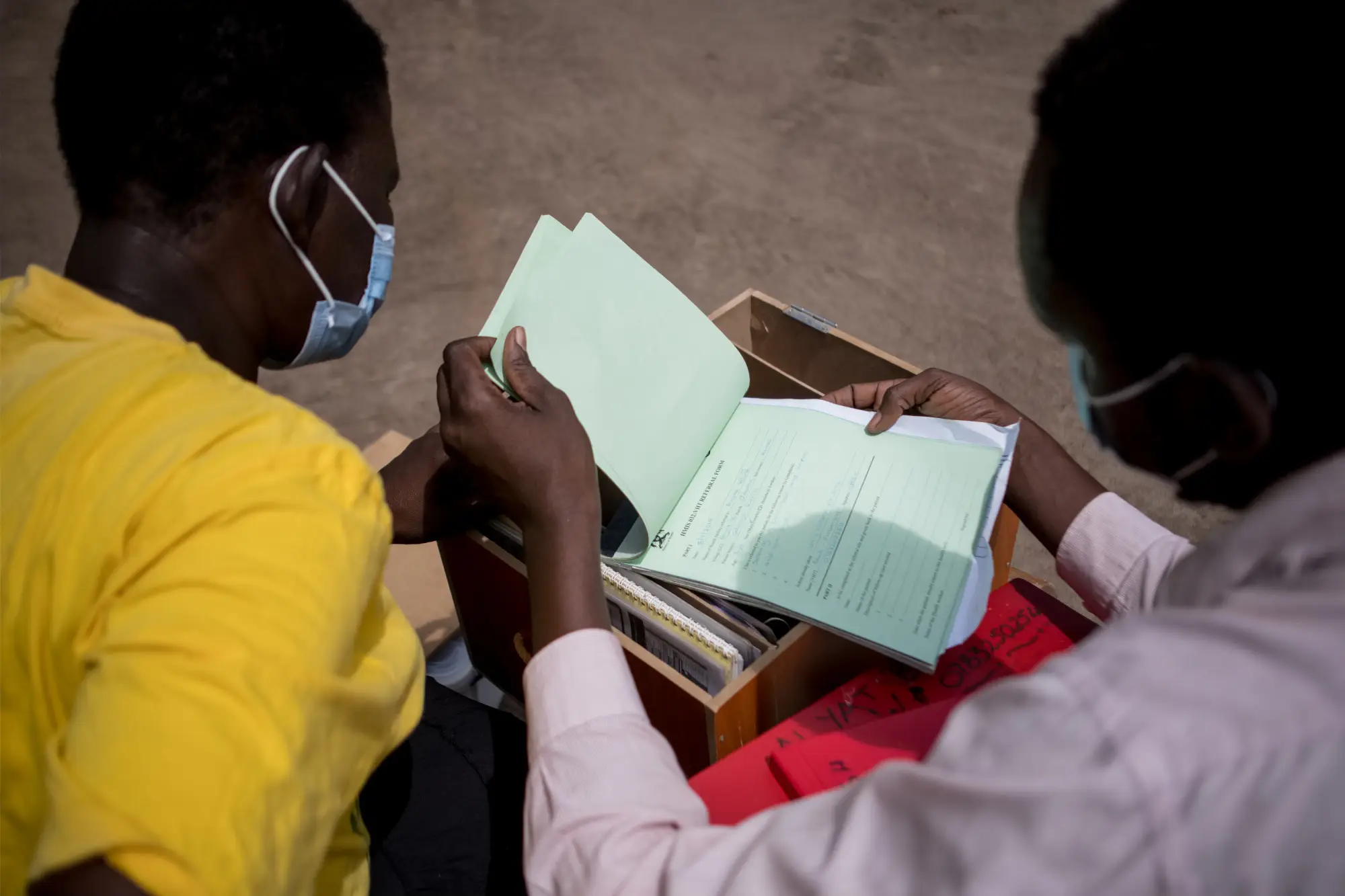 A community health worker reviews documents as part of the SUMRES project in Uganda, June 2022