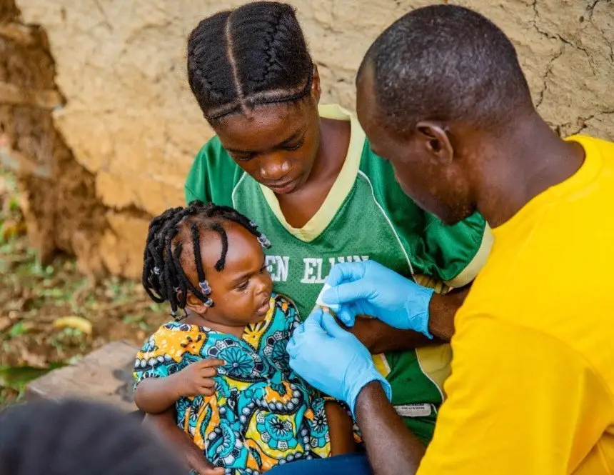 Village health team member, Kato Peter, carries out a malaria test on a child presenting with fever, Buikwe district, Uganda