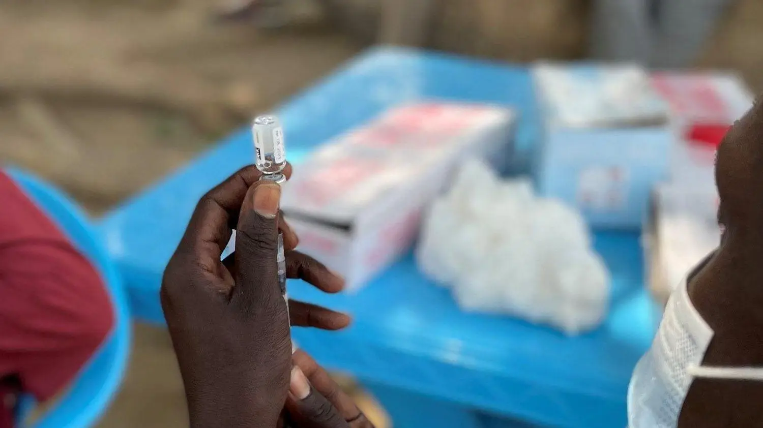 A healthcare workers prepare a vaccine vial