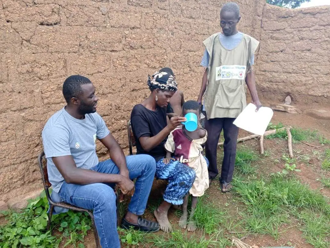 Yempabe sitting with community members
