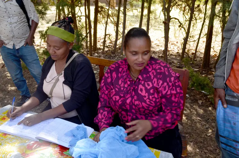 Two women distribute bed nets