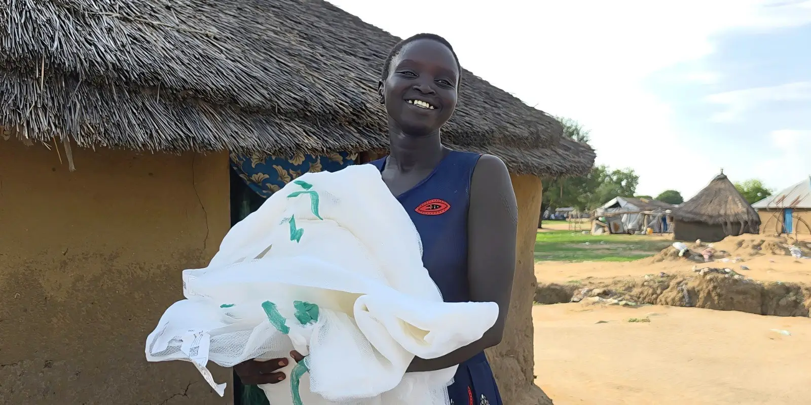 Woman receives long-lasting insecticidal nets during the net distribution campaign in South Sudan