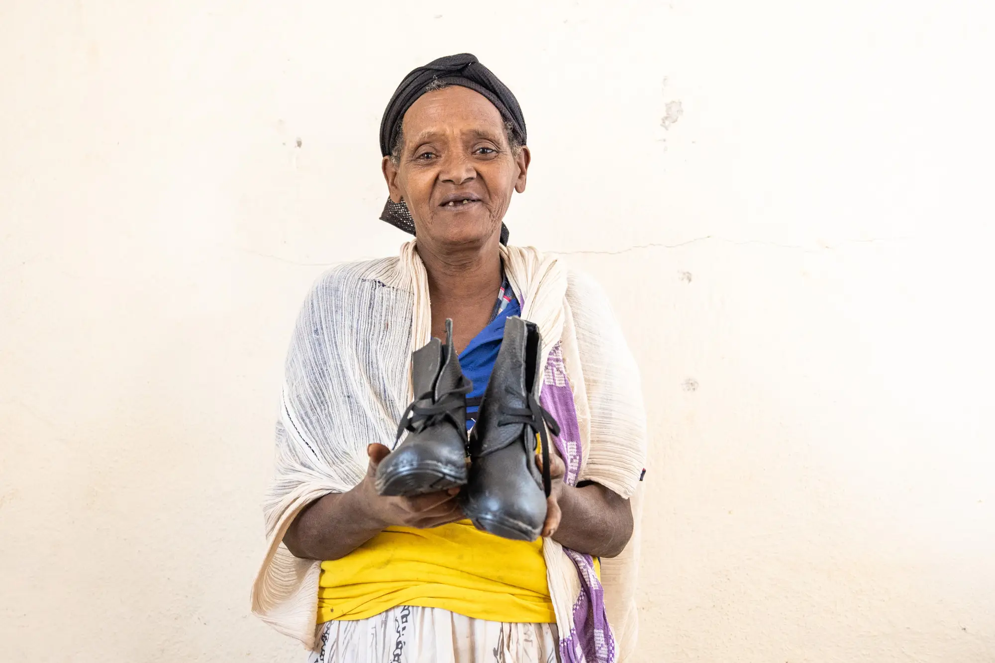 A patient holding large sized shoes, specially adapted to podoconiosis patients, at  Sholla Kodo Health Center Youth Friendly Health Service Center, Ofa woreda, Sodo zuriya, Wolayita, Southern Ethiopia regional state.