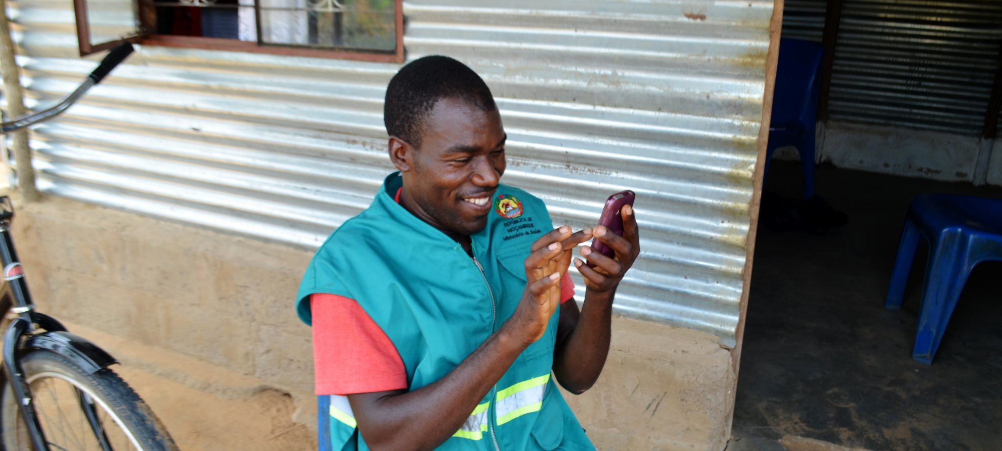 Community health worker using his mobile phone with upSCALE app