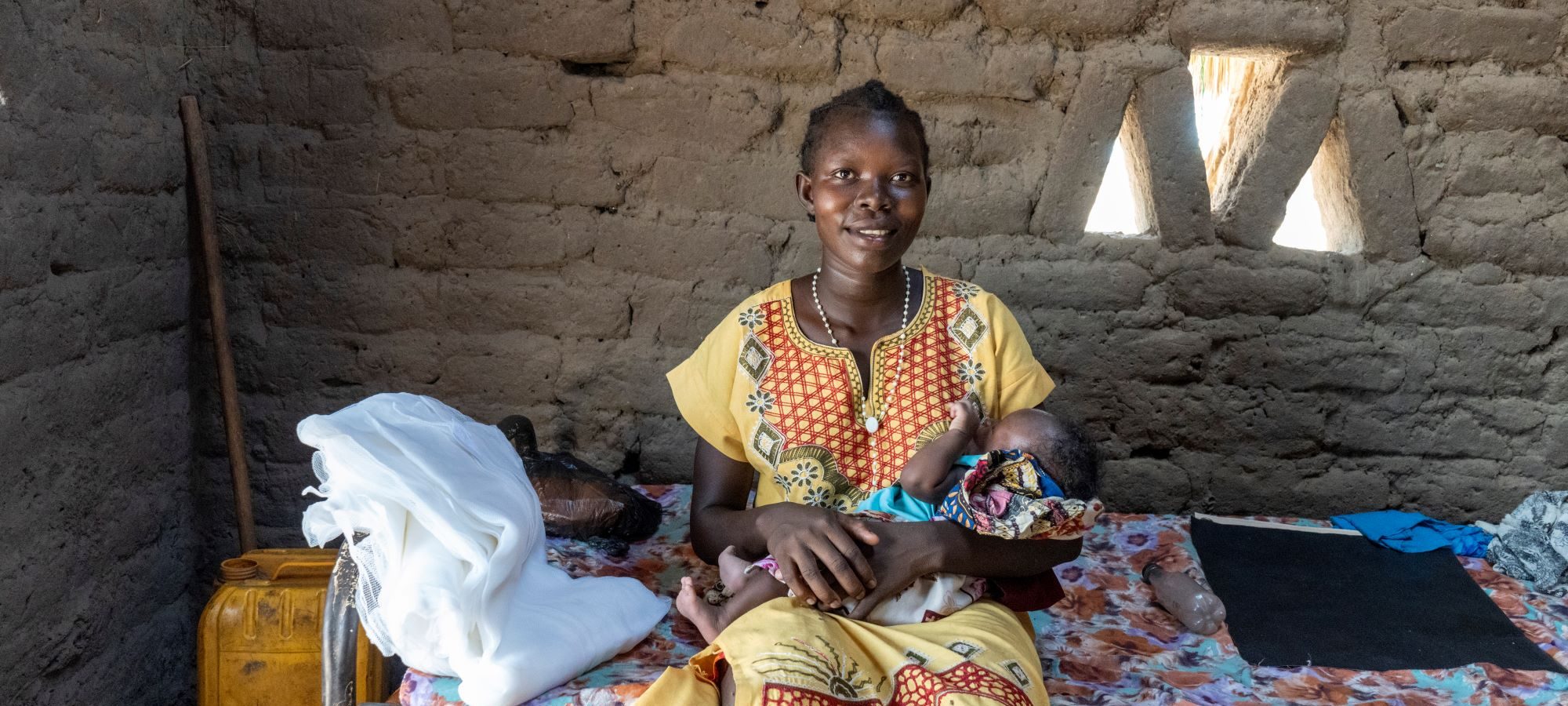 Mother and newborn with long-lasting insecticidal net (LLIN) received as part of distribution campaign in Aweil West, South Sudan