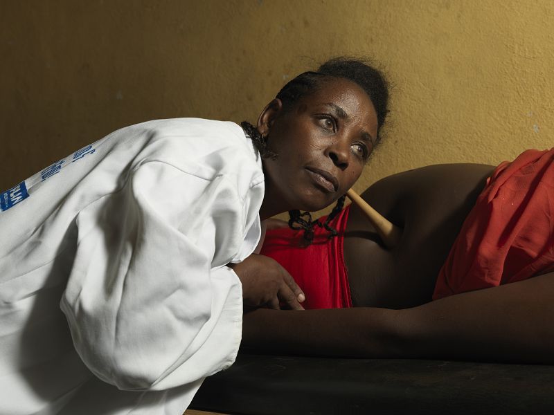 Woman uses Pinard horn to listen to a foetal heartbeat at a health facility in Ethiopia