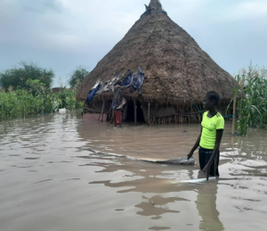 A villager stands outside her flooded house during severe flooding in South Sudan