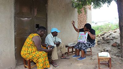To reach all targeted communities with efficient messages, a community health worker is making use of social and behaviour change communications during a home visit in Umojja Village, Nyakasenge sub-county, Kasese district