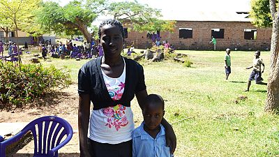 Abbo Kevin and her daughter Stella at Iyolwa Primary School. “I came to this school when I was younger, but I didn’t receive nets. This is the first time. Before, malaria was so high, but now it is going down because of the nets.”
