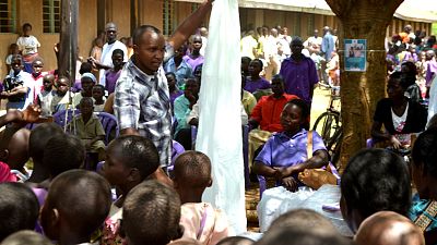 Malaria Consortium’s Julius Lukwago, Technical Officer, shows parents how to properly take care of their nets. 